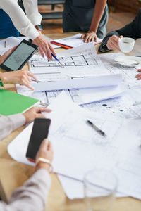 Midsection of business colleagues working on table