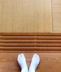 Low section of person wearing socks while standing on hardwood floor