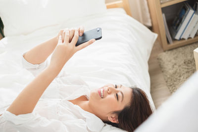 High angle view of woman lying down on bed at home