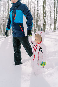 Low section of man skiing on snow covered field