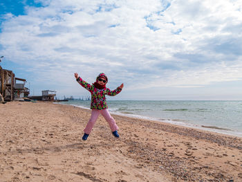 Little girl jumping on empty beach flying in the air lifestyle people scenic landscape active family