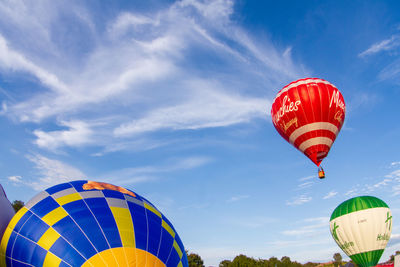 Low angle view of hot air balloons flying against sky