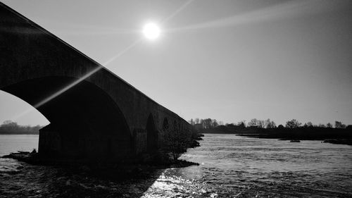 Arch bridge over river against sky