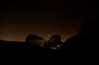 Scenic view of rock formation against sky at night