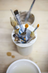 High angle view of paintbrushes in container on table