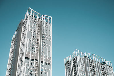 Low angle view of modern apartment building against clear blue sky