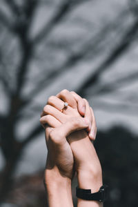 Croppe image of couple with clasped hands outdoors