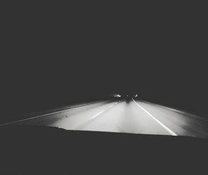 Road seen through car windshield at night