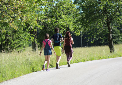 Rear view of women walking on road