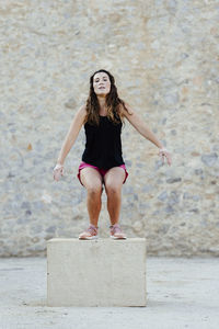 Woman practicing crossfit jumping into a plyometric box.