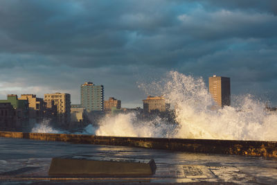 Sea by buildings against sky