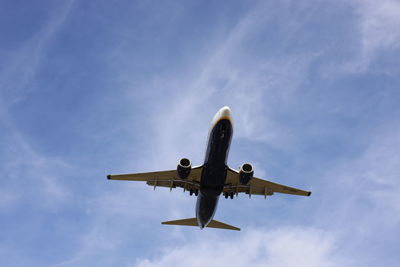 Low angle view of airplane flying against sky