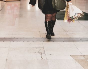 Low section of woman walking on tiled floor