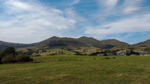 Scenic view of field and mountains against sky