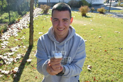 Portrait of smiling man standing on field