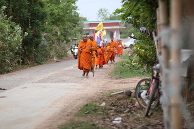 Rear view of people walking on footpath