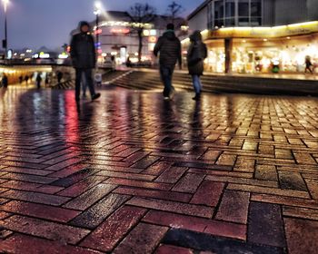 People walking on illuminated street at night