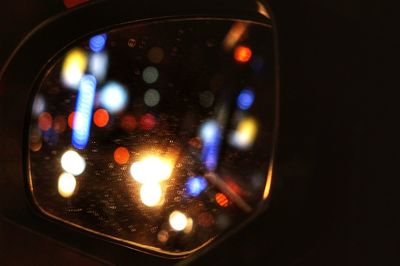 Illuminated lights seen through glass window at night