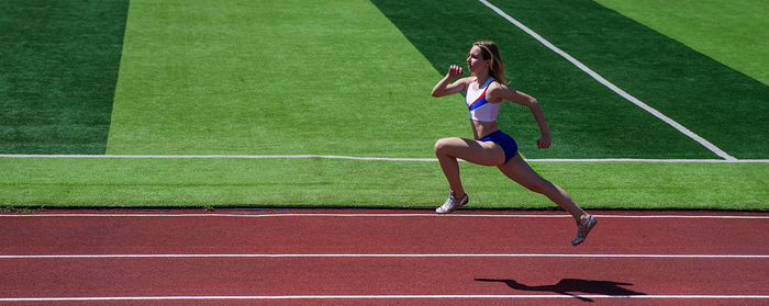 Full length of woman exercising on soccer field