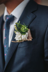 Midsection of man by flower plant