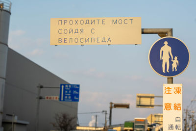 Low angle view of road sign against clear sky