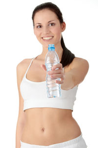 Portrait of a beautiful young woman drinking against white background