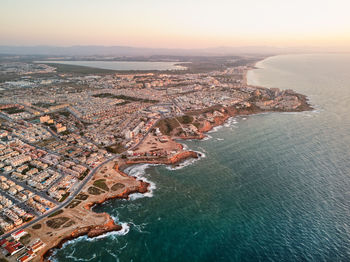 High angle view of buildings by sea against sky