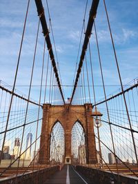 Brooklyn bridge in city against blue sky