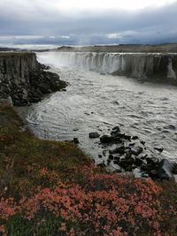 Scenic view of waterfall against sky