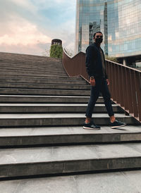 Low angle view of man standing on staircase against sky