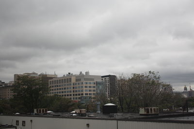 Buildings in city against cloudy sky