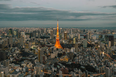 Aerial view of city buildings against cloudy sky