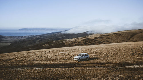 Car on landscape against sky