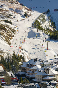 Aerial view, ski lifts and slopes of ski resort with crowds of people skiing seasonal concept