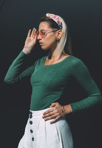 Young woman standing against black background