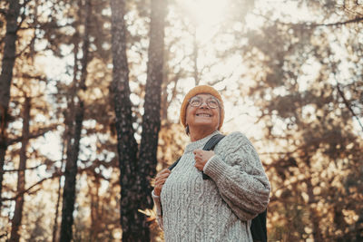 Portrait of young woman standing in forest