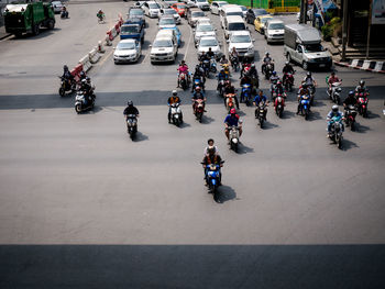 People riding motor scooter on road