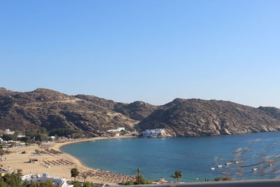 Scenic view of sea and mountains against clear blue sky