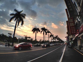 Road passing through city at sunset