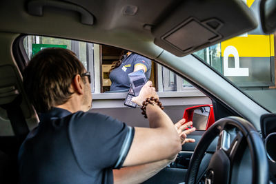 Rear view of man sitting in car