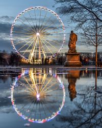 Illuminated ferris wheel against sky at night