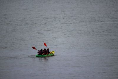 Rear view of people kayaking in river