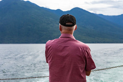 Rear view of man standing against mountain