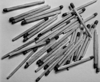 Close-up of scattered matchsticks on white background