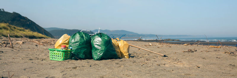 Garbage bags and utensils on the beach after doing a cleaning