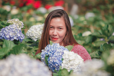 Portrait of woman with pink flowers against blurred background