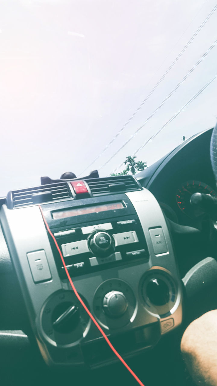 CLOSE-UP OF VINTAGE CAR ON CABLE AGAINST SKY