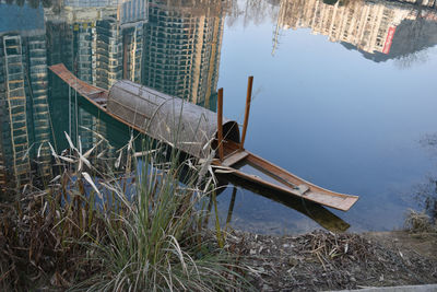 Abandoned boat moored at lake