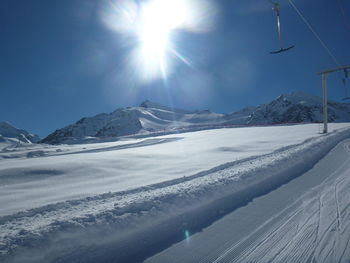 Scenic view of snowcapped mountains against sky on sunny day