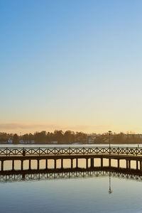 Bridge over water against clear sky during sunset